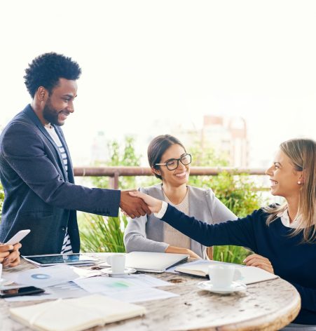 Shot of businesspeople shaking hands during a meeting outdoors.